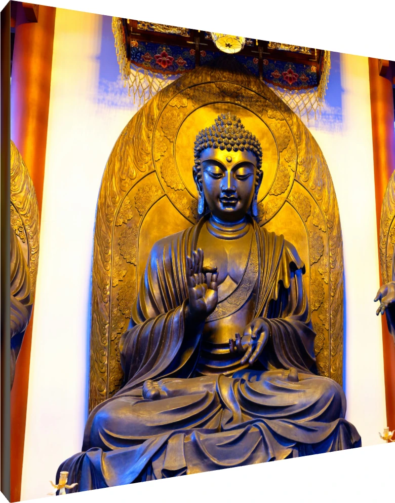 A majestic golden bronze statue of Gautama Buddha seated in meditation inside a temple shrine with warm overhead lighting. | PrintPosters.in