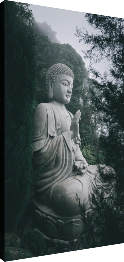 A large stone statue of Lord Buddha meditating amidst a misty green forest, featuring a sacred swastika on his chest. | PrintPosters.in