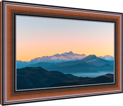 Panoramic view of majestic snow-capped mountain peaks illuminated by golden sunset light with misty blue ridges below. — photo frame preview | PrintPosters.in
